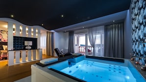 Un moderno spa con una bañera grande con hidromasaje, una camilla de masaje y vistas al balcón.
