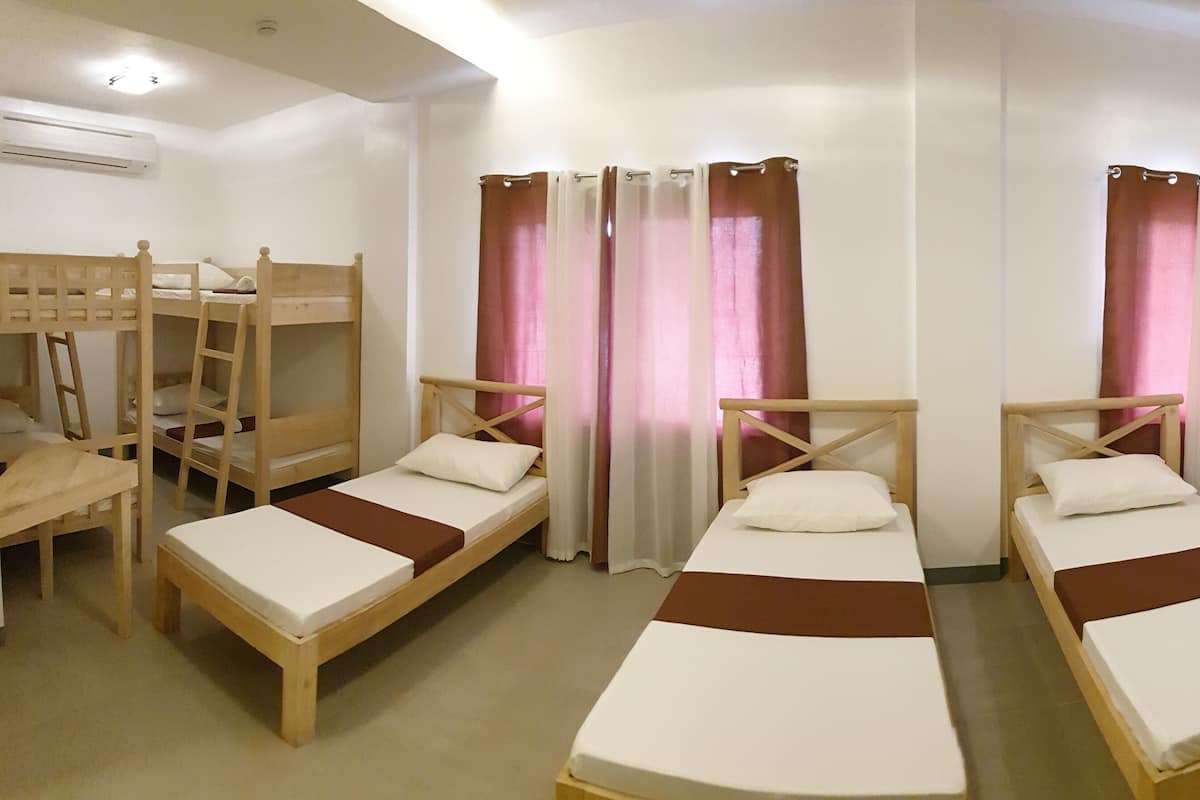 A room with bunk beds, a desk, and a chair.