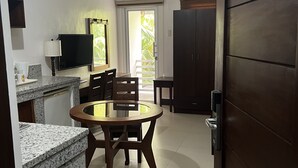 Una cocina moderna con encimeras de granito, un comedor con mesa redonda y sillas, y un armario grande con una puerta marcada 'S1'.
