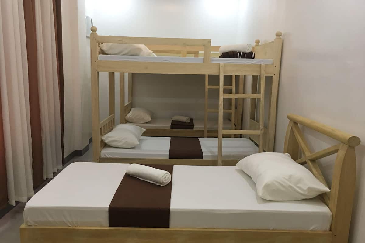 A bunk bed room with two beds, each with a pillow and a rolled towel.