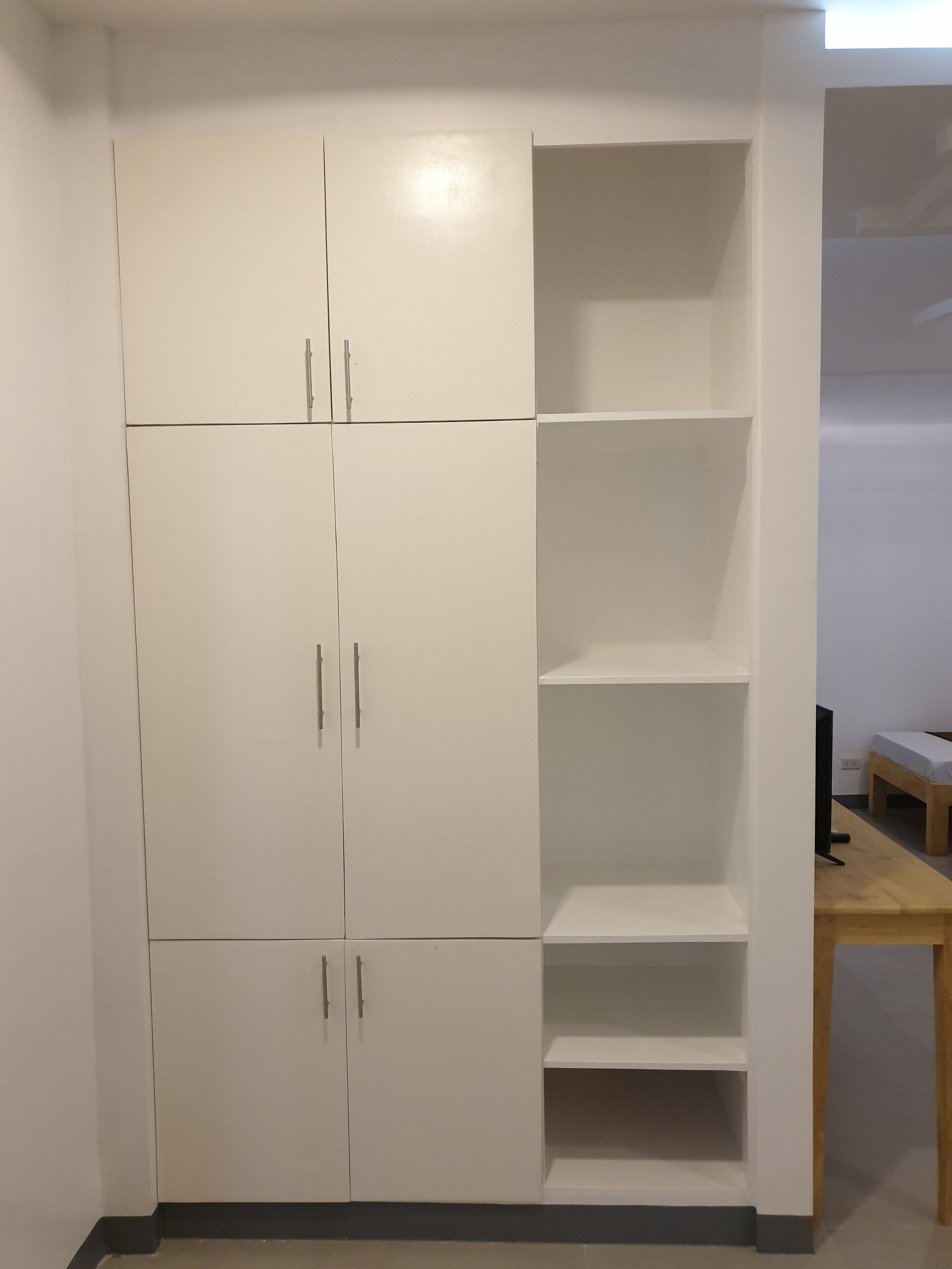 A white wardrobe with multiple doors and shelves.