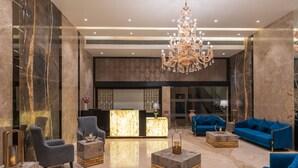 A lobby with marble walls, a chandelier, and blue sofas. - Regenta Central Imperial Candolim Goa (Candolim)