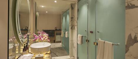 A modern bathroom with a large mirror, a round sink, and marble flooring.