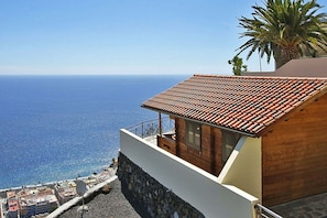 A coastal building with a tiled roof, a balcony, and a view of the sea. - Bungalow Moijama 7, Puerto Naos (Puerto Naos)