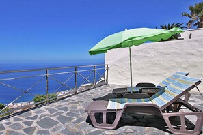 A terrace with two lounge chairs and a green umbrella, overlooking a coastal view. - Bungalow Moijama 12, Puerto Naos (Puerto Naos)