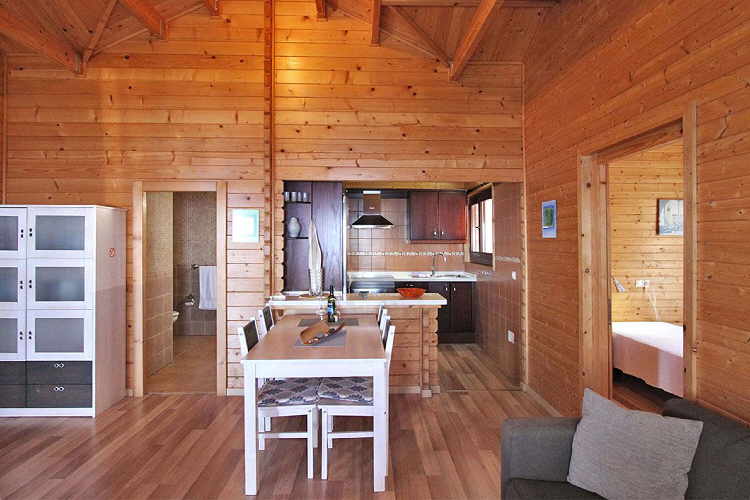 L’intérieur d’une cabane en bois comprend un coin repas, une cuisine et un espace nuit.