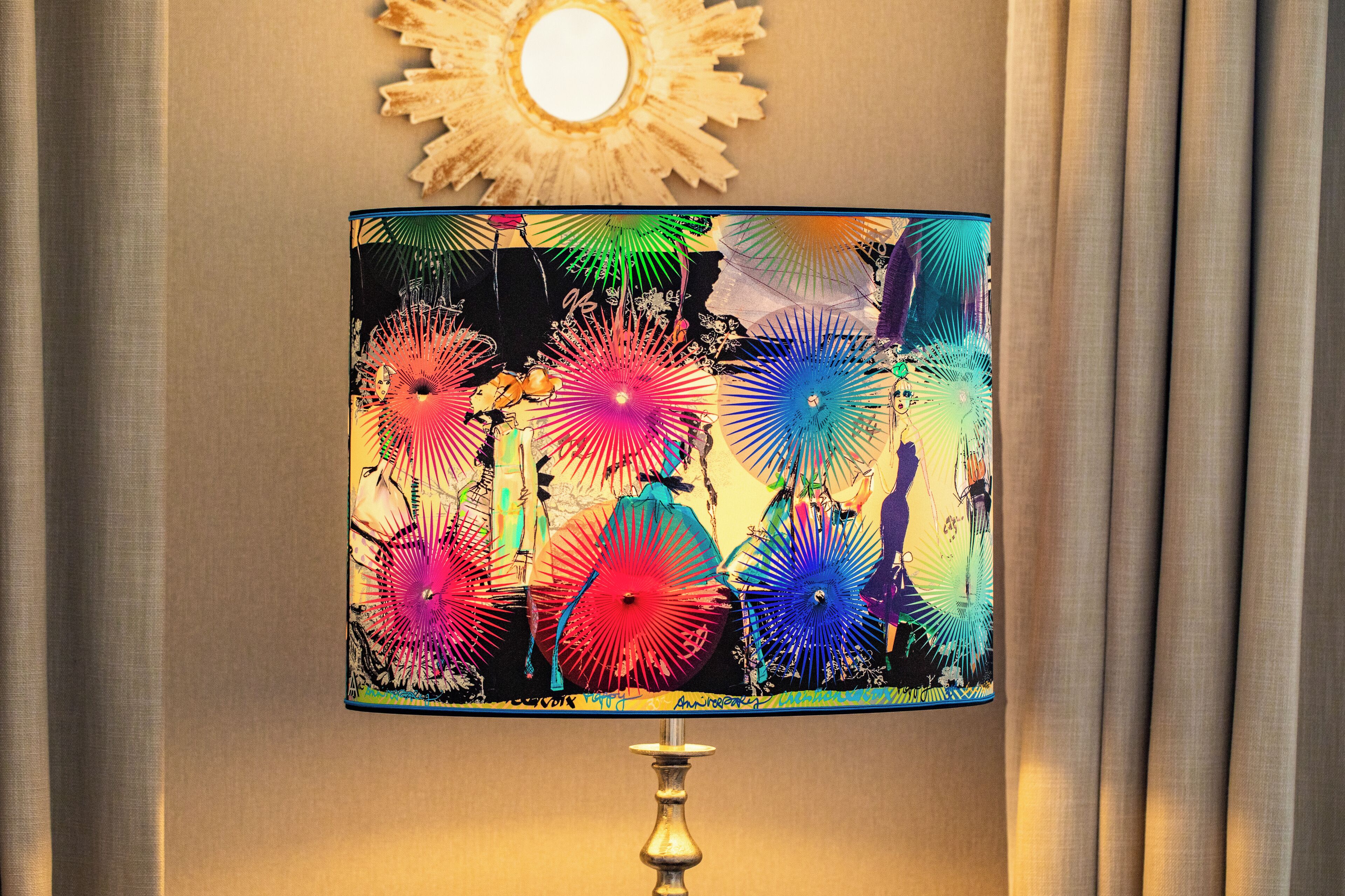 Une lampe dont l’abat-jour présente un motif abstrait et coloré.