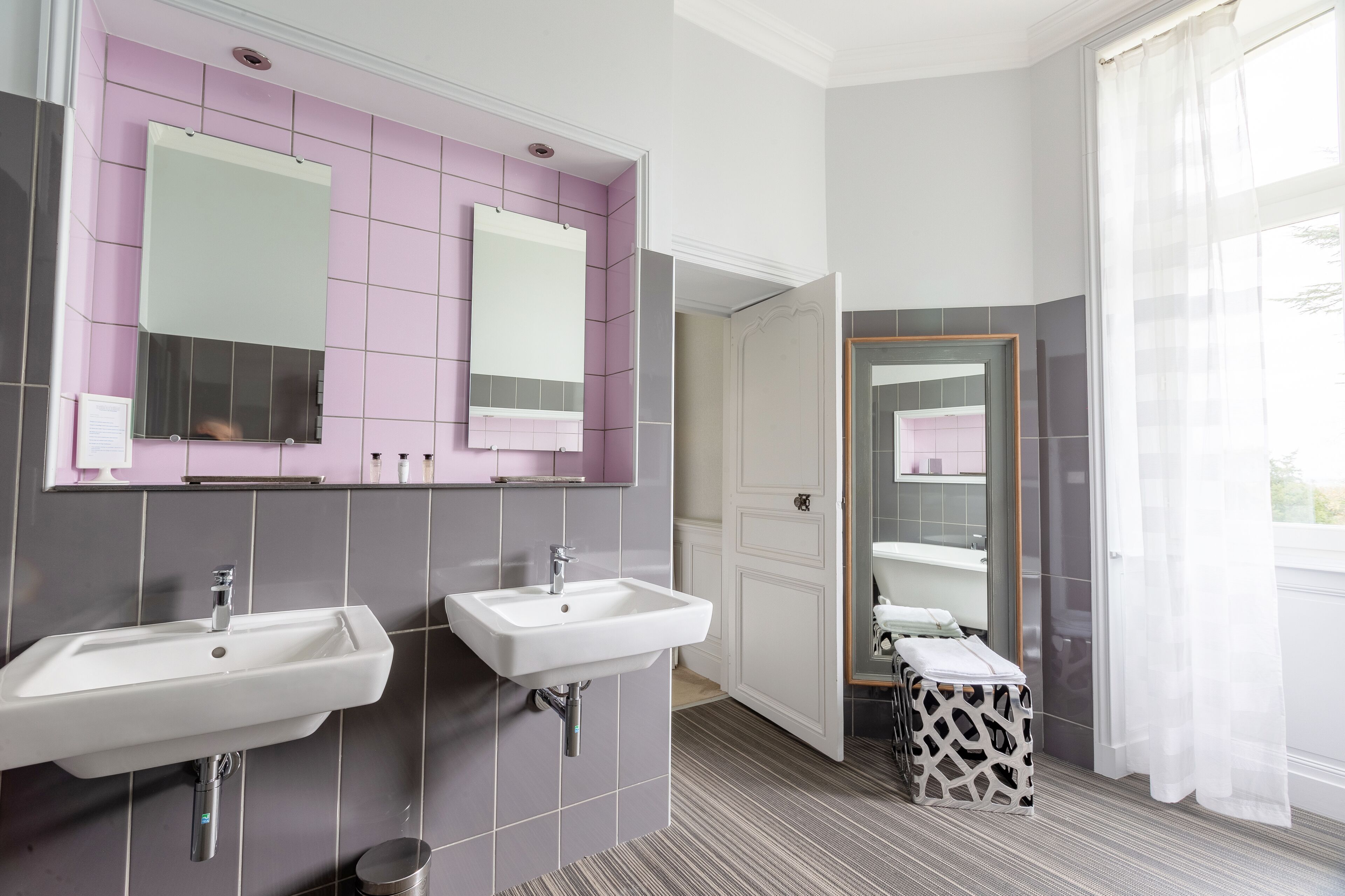 A bathroom with two sinks, a mirror, and a vanity.