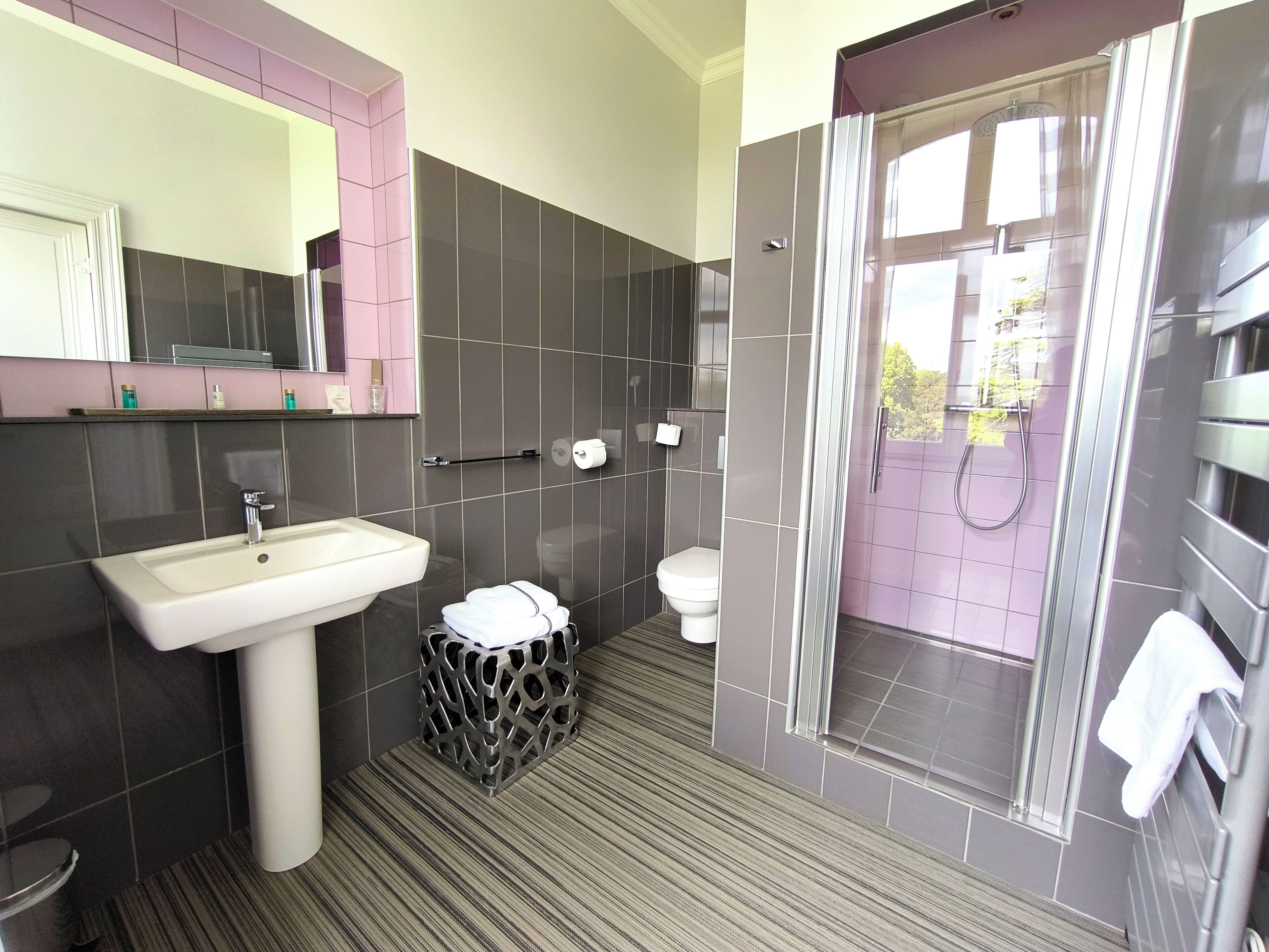A modern bathroom with a sink, toilet, and shower area.