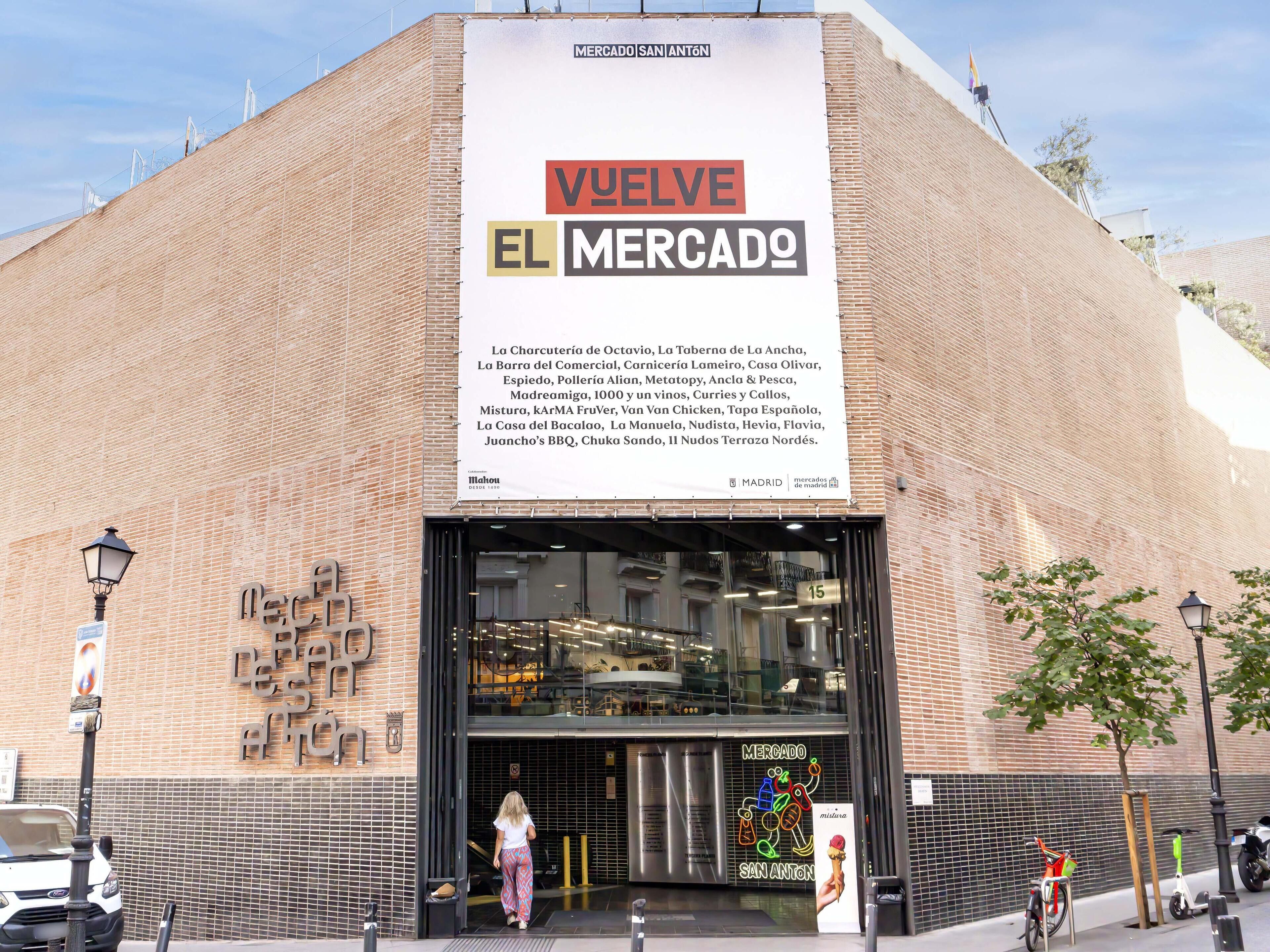 La façade du Mercado San Anton, ornée d’une grande enseigne publicitaire présentant les différents stands de nourriture.