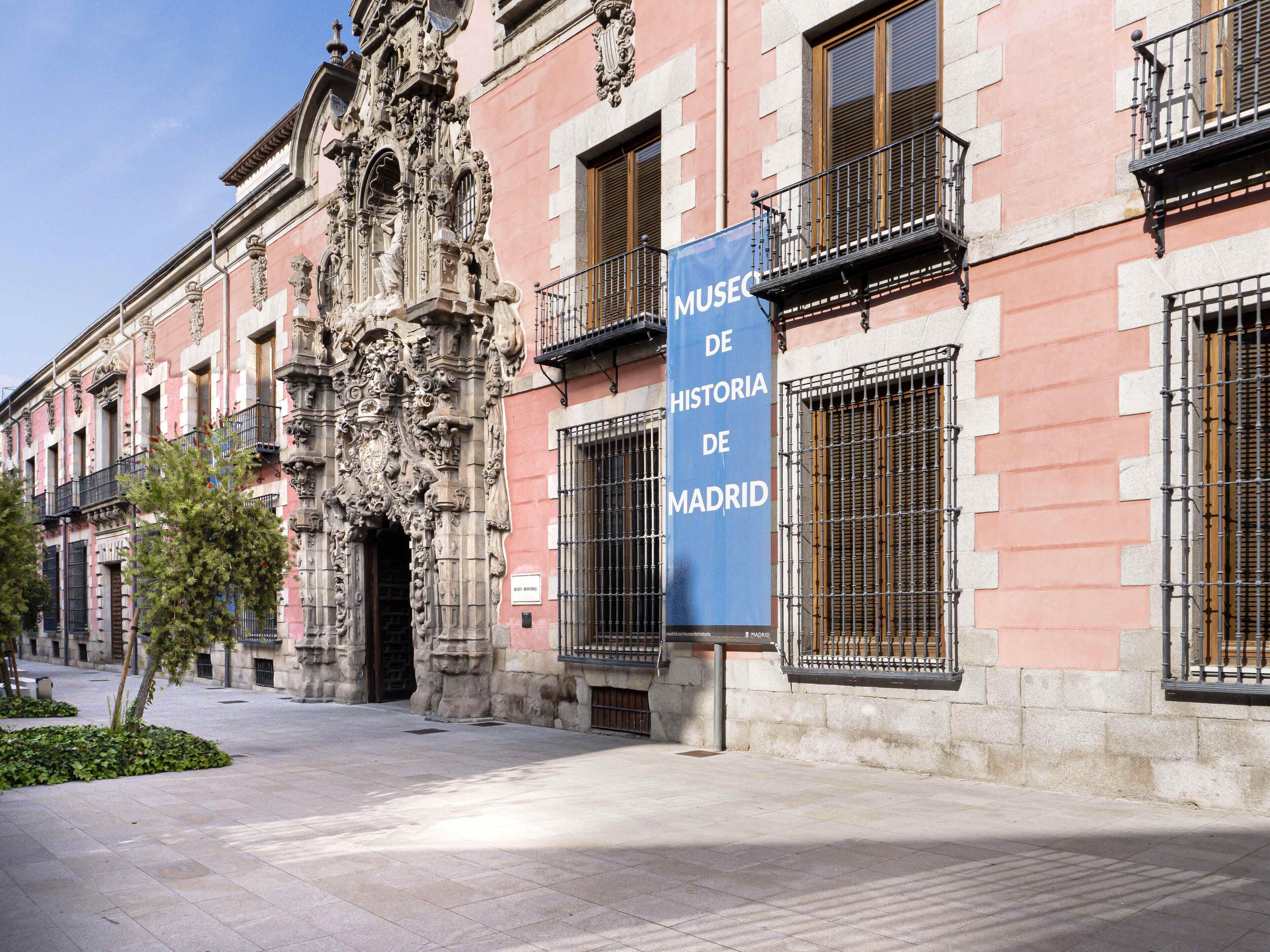 Um edifício histórico com arquitetura ornamentada e uma faixa azul com a inscrição 