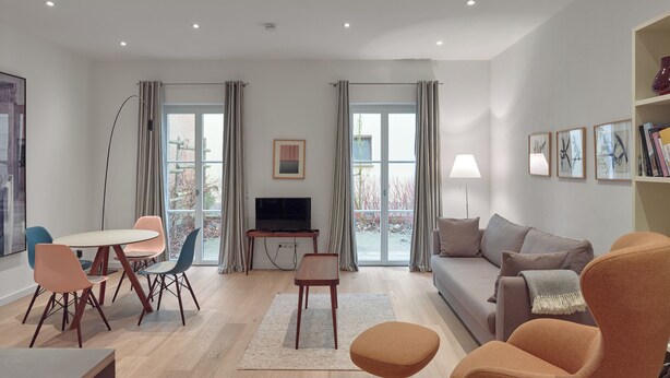 A modern living room with a sofa, chairs, a TV, and a bookshelf. - Gästehaus Cantzheim I Ferienwohung Fuchs - Cantzheim.dorf (Kanzem)