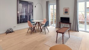 A modern living room with a dining area, a flat-screen TV, and a large abstract painting. - Gästehaus Cantzheim I Ferienwohung Fuchs - Cantzheim.dorf (Kanzem)