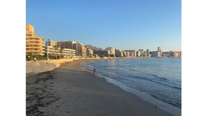 Une plage avec, en arrière-plan, une vue sur la ville, comprenant un mélange d’immeubles de grande et de petite hauteur.