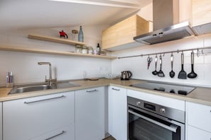 A modern kitchen with white cabinets, stainless steel appliances, wooden countertops, and a variety of utensils hanging on the wall. - Cozy studio apartment located in a strategic position just 850m from the yellow metro line M3 heading to Central Station / Piazza Duomo and 700m from the 'Affori' bus stop.The accommodation has all the main comforts, double bed, Two balconies and double  (Milano)