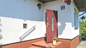 A building with a red door, number 18, a small window, and a metal handrail. - Pet friendly home in Warnoleka with WiFi (Warnoleka)