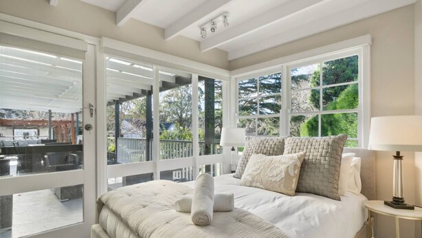 Un dormitorio con una cama grande, vistas al exterior y un balcón.