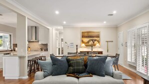 Amplia sala de estar con un sofá, una mesa de comedor y una cocina al fondo.