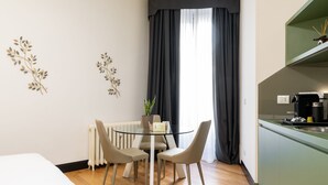 Ein kompakter Wohnbereich mit Essplatz, Küchenzeile und einem Bett.