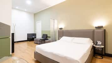 Una camera d'albergo moderna con un grande letto, comodini, una TV a schermo piatto e uno specchio.