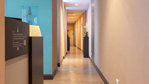 Ein Hotelgang mit freiem Blick auf den Empfangsbereich, inklusive einer Rezeption und einem Schild.