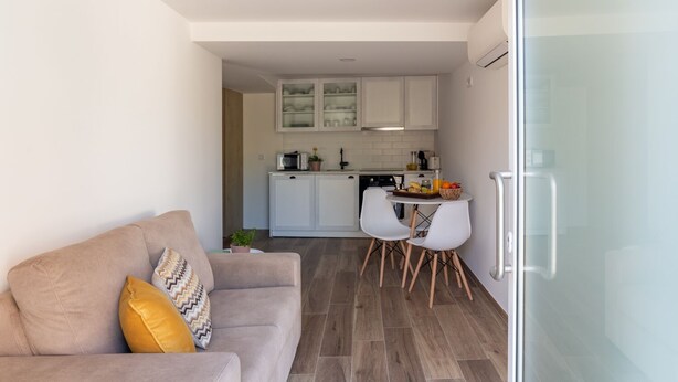 Ein modernes Wohnzimmer mit einer Couch und einem Essbereich mit Tisch und Stühlen.