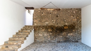 Eine steile Steintreppe führt zu einer Steinmauer, an der eine Hängeleuchte befestigt ist.
