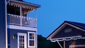 A two-story house with a balcony and a covered porch area.