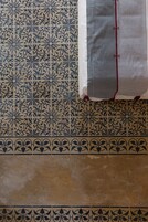 Piso de azulejos estampados com uma borda decorativa.