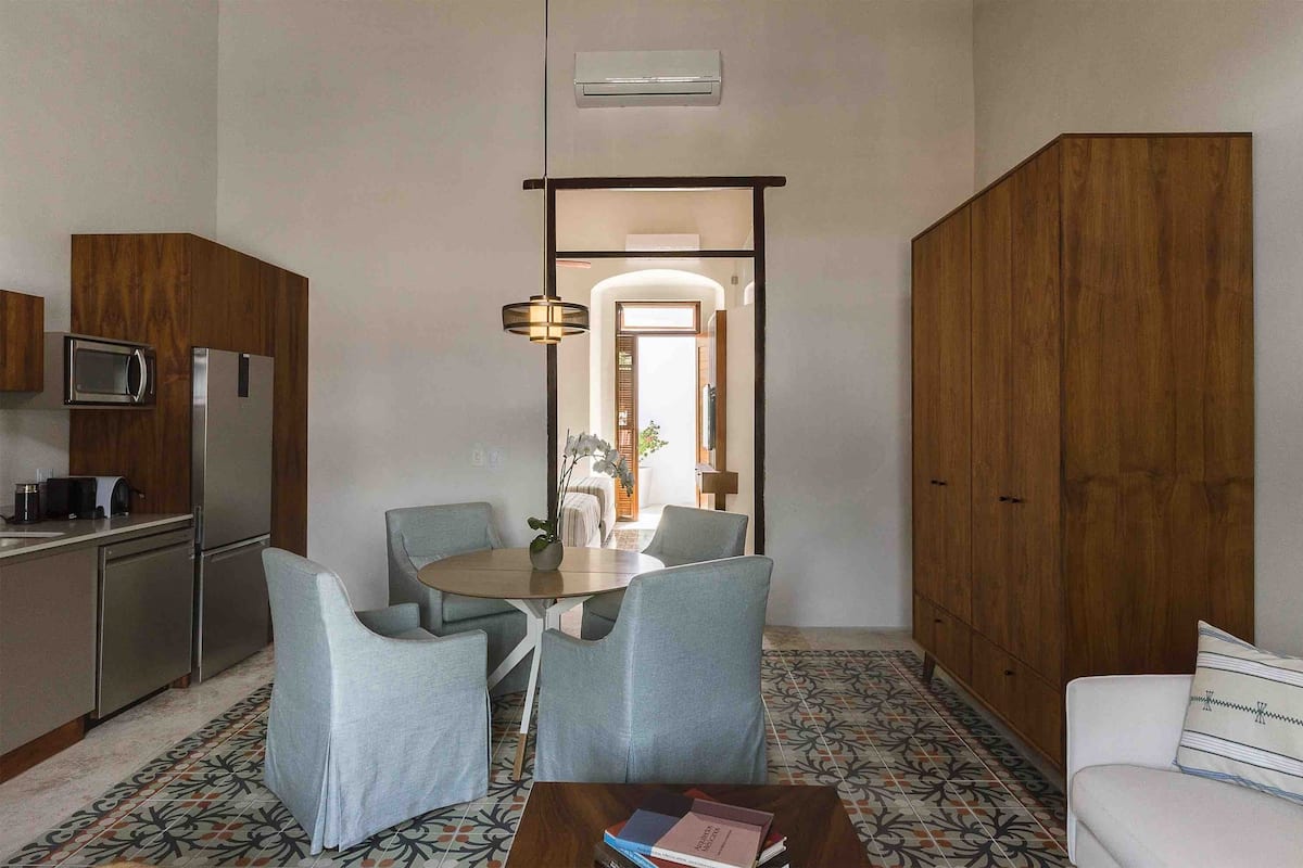 Un espacio habitable compacto con kitchenette, comedor y un armario grande.