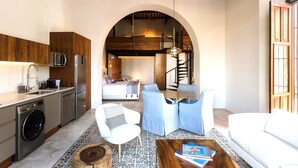 Un espace de vie compact comprenant une cuisine, un coin repas et une chambre.