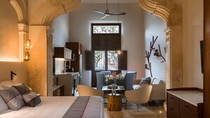 Une chambre spacieuse avec un grand lit, un coin repas et une cuisine.