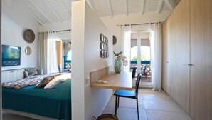 Quarto com cama, escrivaninha, cadeira, janela e porta.