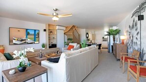 Uma sala de estar moderna com sofá, mesa de centro e área de jantar com cadeiras.