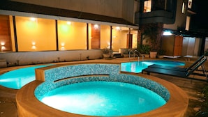 A hot tub with a tiled interior, surrounded by lounge chairs and potted plants. - Rosetum Anjuna (Anjuna)