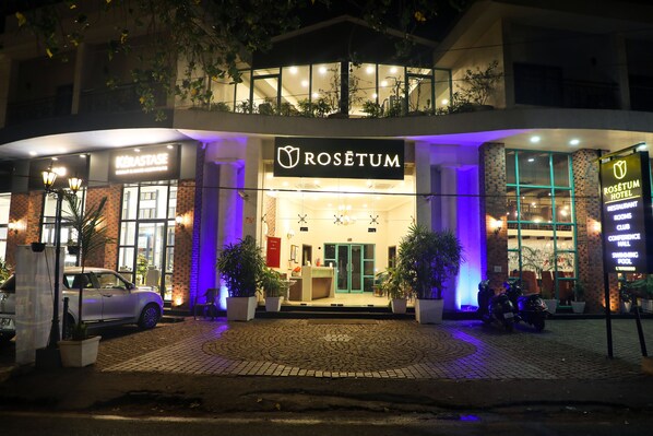 Entrada de un hotel con un cartel que dice 'Rosetum Hotel' y 'Salón de Conferencias'.
