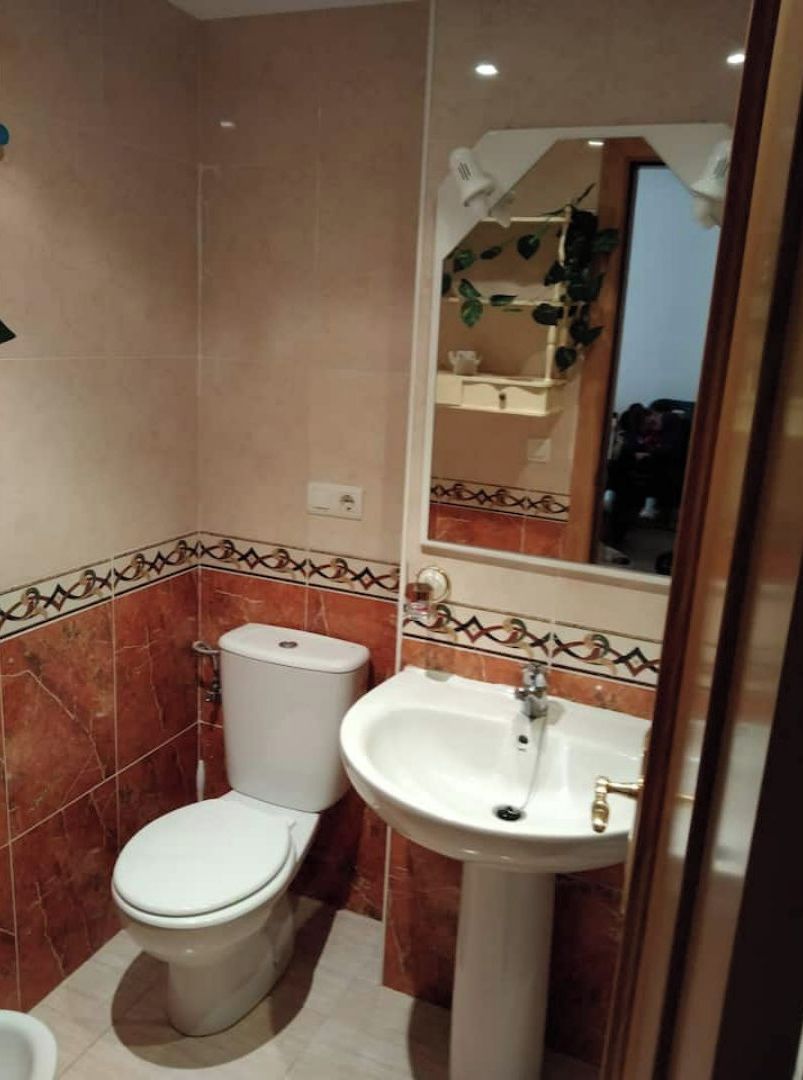 A bathroom with a toilet, bidet, and sink.