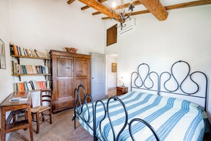 A bedroom with a bed, wooden furniture, and bookshelves. - Semidetached Villa Shared Pool (Monteleone d'Orvieto)