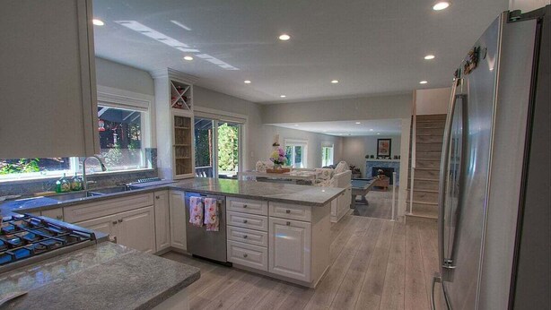 Una cocina amplia con una isla grande, electrodomésticos integrados y mucho espacio de almacenamiento.