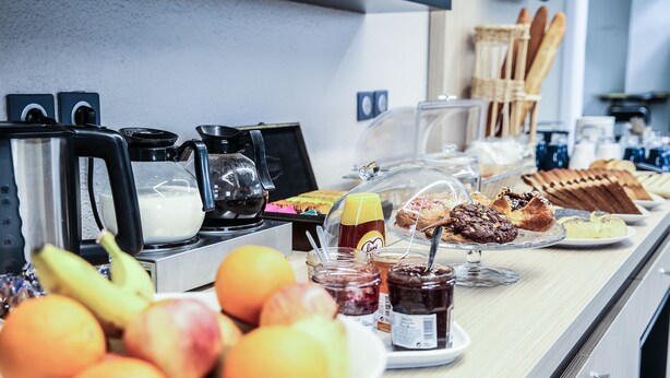 Un buffet de petit-déjeuner comprenant des fruits, des viennoiseries et diverses garnitures.