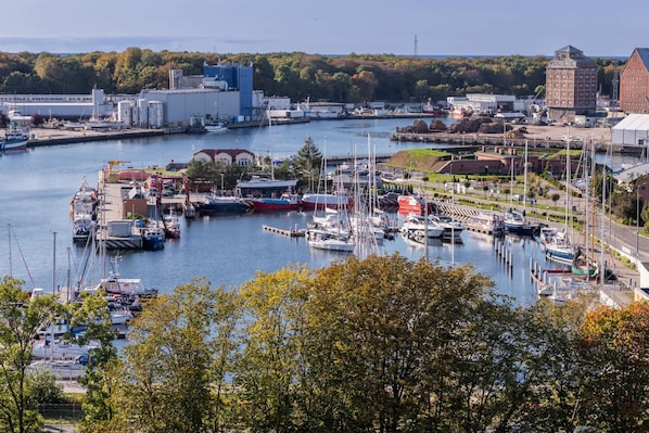 A marina with boats docked, a large industrial building, and a red brick structure.