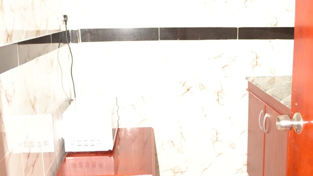 A bathroom with a wooden vanity, a sink, and a cabinet. - Morena Hotel Dodoma (Dodoma)
