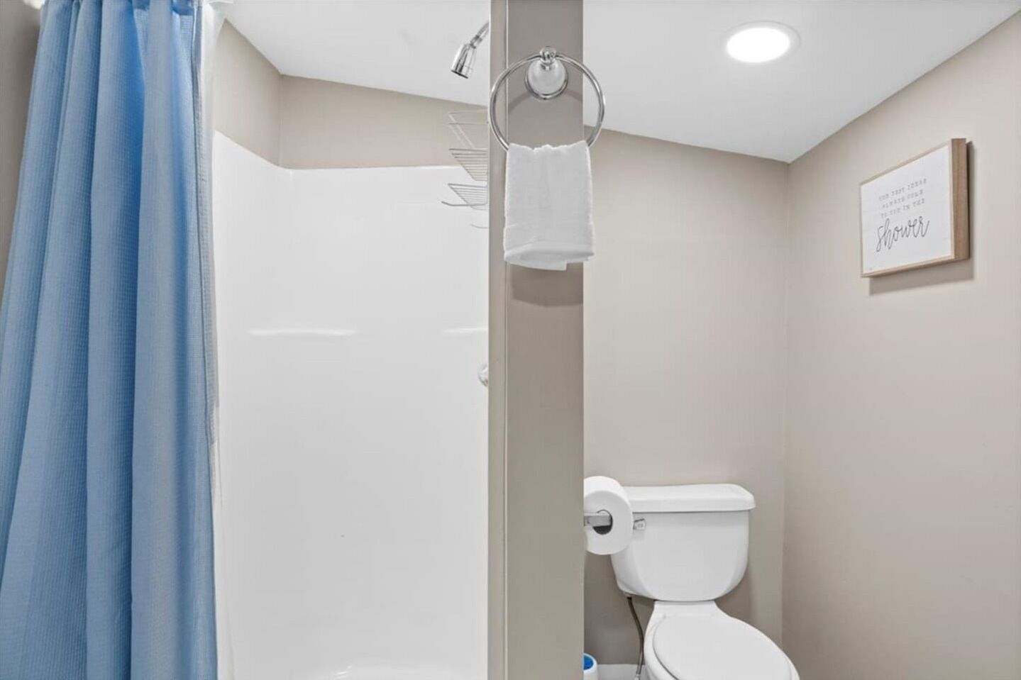 Een badkamer met douche, toilet en handdoekrek.