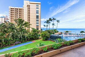 A hotel with a pool, palm trees, and a view of the ocean.