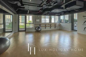 A spacious room with large windows, a ballet barre, and an exercise ball.