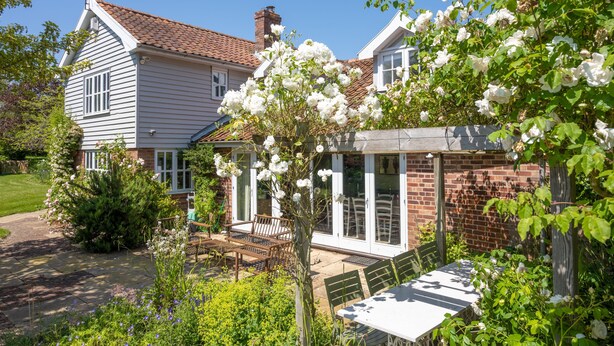A two-story house with a patio area, a dining table, and chairs. - Foxhole Cottage,  Framsden, Framlingham (Stowmarket)