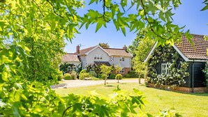 A two-story house with a tiled roof, surrounded by a well-maintained lawn and various trees. - Foxhole Cottage,  Framsden, Framlingham (Stowmarket)