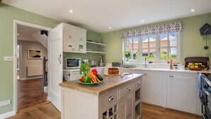 A kitchen with white cabinets, a wooden countertop, and a window with patterned valance. - Foxhole Cottage,  Framsden, Framlingham (Stowmarket)