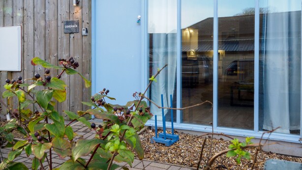 A modern building with a large glass door and a wooden exterior. - Coverack (Falmouth)