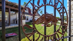 Un letrero de metal con un toro y la palabra "BULLS" en un diseño circular, sujeto a una cerca metálica.